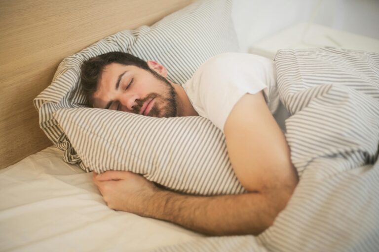 Man sleeping soundly while cradling his pillow