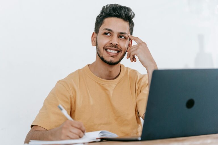 Man thinking deeply while trying to write in his notebook