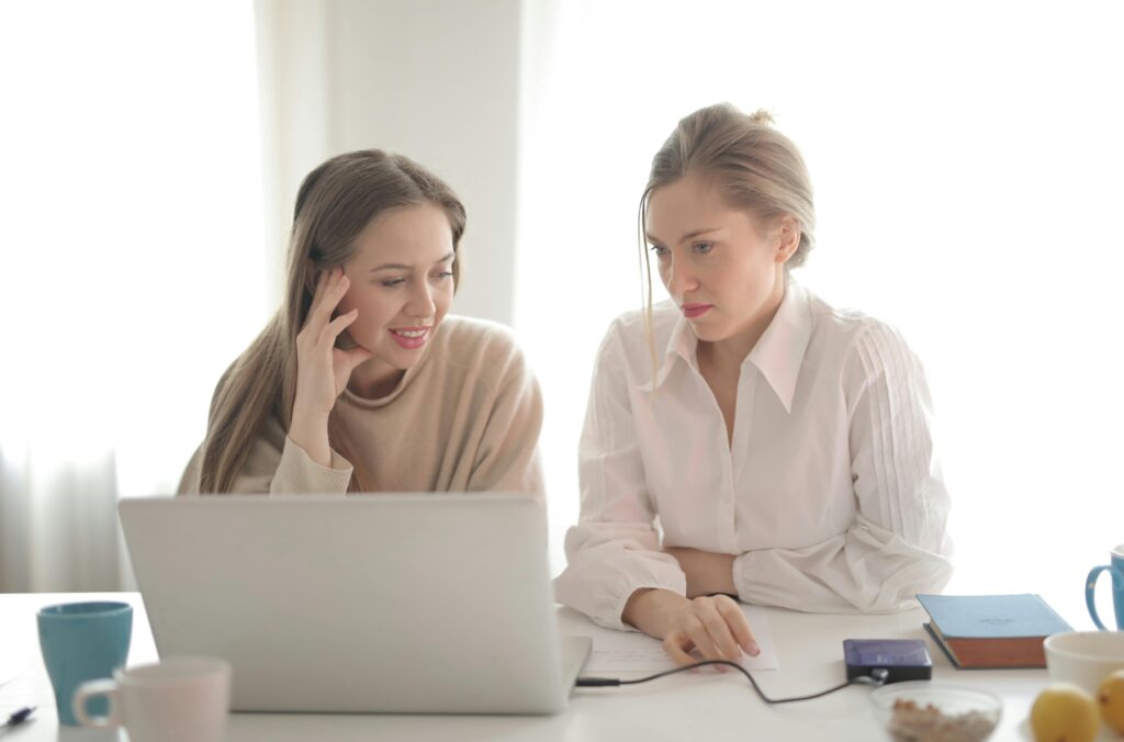 Two women looking at a laptop screen