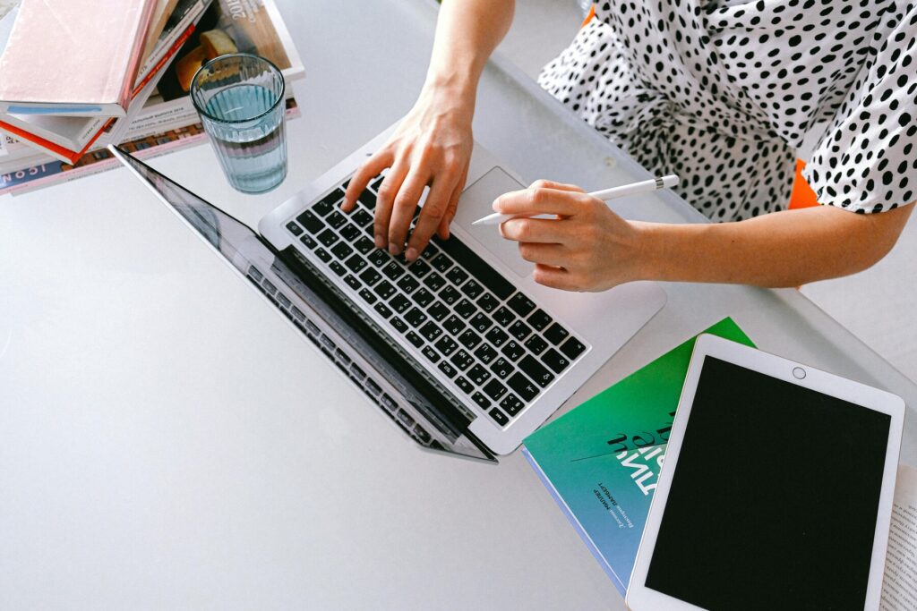 Woman holding a stylus pen while using her laptop